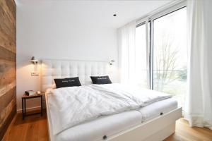 Una habitación blanca con una cama blanca y una ventana grande en Fewo Moby Dick, en Norderney