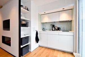 cocina con armarios blancos y TV en Fewo Moby Dick, en Norderney