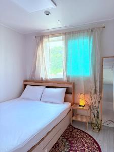 une chambre avec un grand lit et une fenêtre dans l'établissement MAYs GO DUCK Newly built Family Stay KSPO IKEA Lotte World, à Séoul