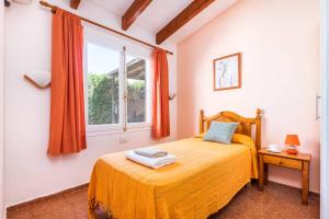 a bedroom with a bed with orange sheets and a window at Villa Iris Prima by Villa Plus in Punta Prima +11 photos