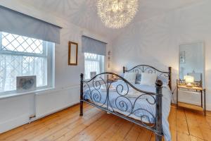 a bedroom with a bed and a chandelier at Millers Cottage in Broadstairs