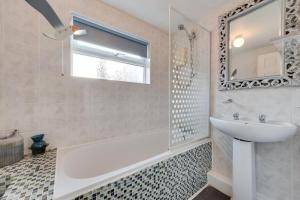 a bathroom with a tub and a sink and a mirror at Millers Cottage in Broadstairs +16 photos