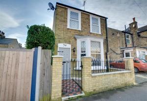 a brick house with a gate and a fence at Millers Cottage in Broadstairs