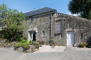 an old stone building with a white door at Teign Cottage in Broadhempston