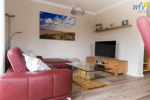 Televiisor ja/või meelelahutuskeskus majutusasutuses Ferienhaus Melkerpad 28 Ferienwohnung Inselzauber