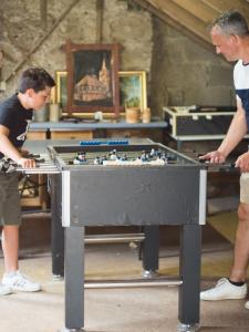 due uomini stanno giocando con un tavolo da biliardo di Ferienhof Henn a Tauberrettersheim