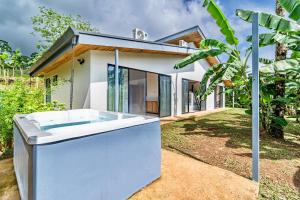 a bath tub in front of a house at Private rainforest villa up to 8 guests w jacuzzi near Rio Celeste in Upala