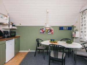 a kitchen and dining room with a table and chairs at 4 person holiday home in Rømø in Sønderby