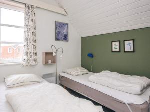 two beds in a room with a green wall at 4 person holiday home in Rømø in Sønderby +42 photos