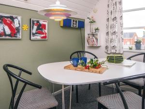 a dining room with a white table and chairs at 4 person holiday home in Rømø in Sønderby