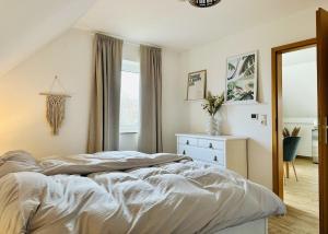 a bedroom with a bed and a dresser and a window at Havnkoje 2 in Westerbergen