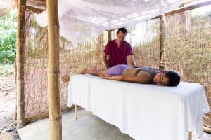 a man laying on a table with a woman at Private rainforest villa up to 8 guests w jacuzzi near Rio Celeste in Upala