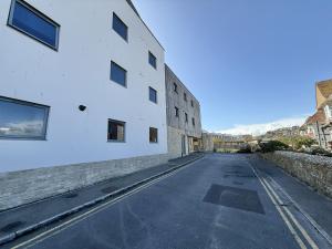 Une rue vide à côté d'un bâtiment blanc dans l'établissement Octopus, à West Bay