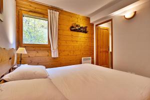 尚帕尼恩瓦努瓦茲Bijolin 4/6 personnes, Spa & Terrasse的一间卧室，有一张白色的床和一扇窗户