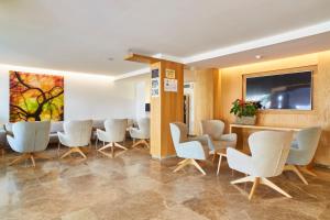a waiting room with white chairs and a table at Aptos Casa Luis by Invisa in Santa Eularia des Riu