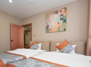 two beds in a room with a painting on the wall at Amgun Hotel Ulaanbaatar in Ulaanbaatar