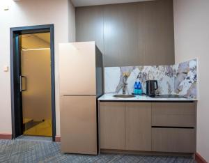 a kitchen with a refrigerator and a sink at Amgun Hotel Ulaanbaatar in Ulaanbaatar