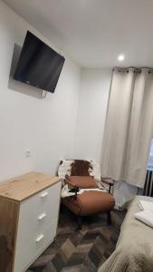 a bedroom with a dresser and a tv on the wall at hotel de la gare in Modane