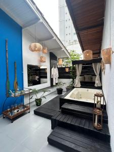 a bathroom with a tub and a blue wall at Flat 300m da Praia e Roda Gigante 2 andar com jacuzzi privativa in Balneário Camboriú +39 photos