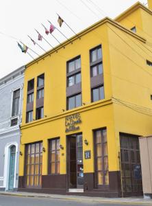 a yellow building with flags on top of it at Hotel La Quinta de Allison in Lima