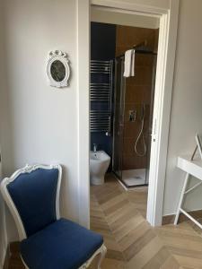 a bathroom with a blue chair and a shower at B&B La Rotonda in Naples