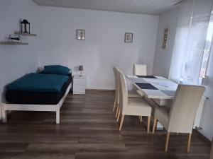a dining room with a table and chairs and a bed at Monteurwohnung in Wilnsdorf