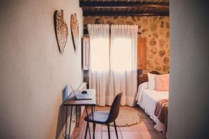a bedroom with a bed and a desk and a chair at Casa Rural La Vega Piscina, naturaleza y vistas in San Vicente de Alcántara +42 photos