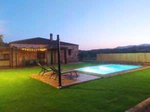 a backyard with a swimming pool and a house at Casa Rural La Vega Piscina, naturaleza y vistas in San Vicente de Alcántara