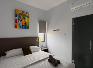a bedroom with a bed and a painting on the wall at TJ Brother Residences Cengkareng in Jakarta