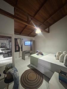 a bedroom with a bed and a living room at Flat 300m da Praia e Roda Gigante 2 andar com jacuzzi privativa in Balneário Camboriú