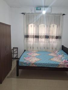 a bedroom with a bed with a curtain at Golden Gate Ways Villa in Hikkaduwa
