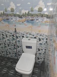 a toilet in a bathroom with a mural of a beach at Golden Gate Ways Villa in Hikkaduwa