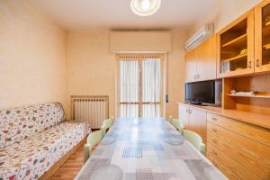 un soggiorno con un lungo tavolo e un divano di Blue Sky House a Ceriale