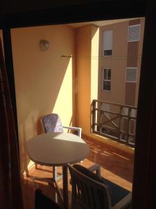 a table and chairs in a room with a balcony at Apartamento Muelle de Corralejo 14 in Corralejo