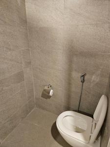Un baño con un inodoro blanco en una cabina. en Restful Retreat, en Greater Noida