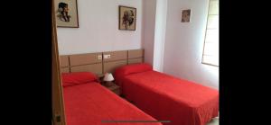 une petite chambre avec deux lits et un miroir dans l'établissement Escapada Ideal en Oropesa, à El Borseral