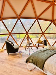 Zimmer mit einem Bett und einem Stuhl in einem Zelt in der Unterkunft La bulle d'Ostara 