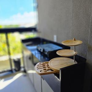 a counter top with two wooden stools on it at Cais Eco Residência in Porto De Galinhas