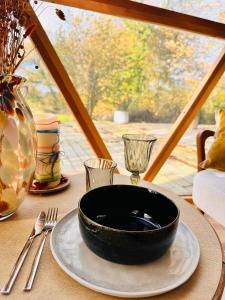 eine schwarze Schüssel auf einem Teller auf einem Tisch in der Unterkunft La bulle d'Ostara 