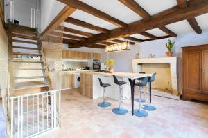 a kitchen with a table and stools in a room at Gite La Ferme En Sud Charente in Montboyer +30 photos