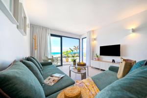 a living room with a blue couch and a television at Amapola Palms - recién reformado, frente al mar in San Agustin