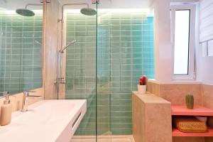 a bathroom with green tiles and a shower at Amapola Palms - recién reformado, frente al mar in San Agustin +31 photos
