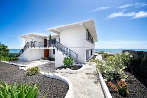 a white house with a view of the ocean at Amapola Palms - recién reformado, frente al mar in San Agustin