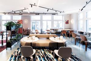 a restaurant with tables and chairs and windows at Sorell Boutique-Hotel City Weissenstein St Gallen in St. Gallen