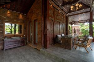 ein Raum mit einem Tisch und Stühlen in einem Gebäude in der Unterkunft Aksmi Suites & Villas in Bedahulu