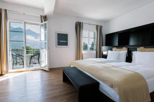 a bedroom with a large bed and a large window at Sorell Hotel Tamina Bad Ragaz in Bad Ragaz