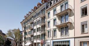 Un gran edificio blanco con balcones en una calle. en Sorell Hotel Arabelle Bern, en Berna
