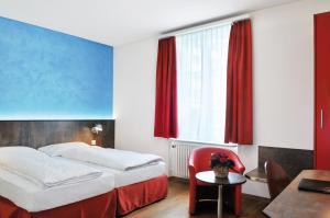 a hotel room with a bed and a table and a chair at Sorell Hotel Arabelle Bern in Bern