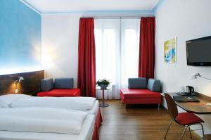 a hotel room with two beds and a desk at Sorell Hotel Arabelle Bern in Bern