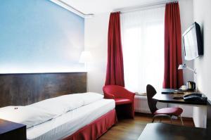 a hotel room with a bed and a desk at Sorell Hotel Arabelle Bern in Bern